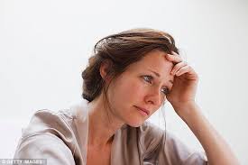 woman with worried look resting head in hand